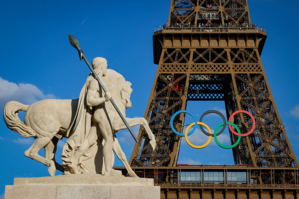 Olympic rings on the Eiffel Tower near the restored statue Cavalier Arabe (Arab rider) on the Pont d'Iena bridge, Paris, 2024, ahead of the upcoming Paris 2024 Olympic Games.