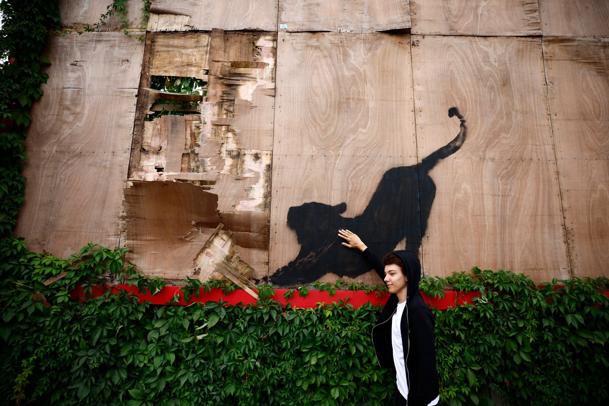 A painting of a black cat on a billboard.