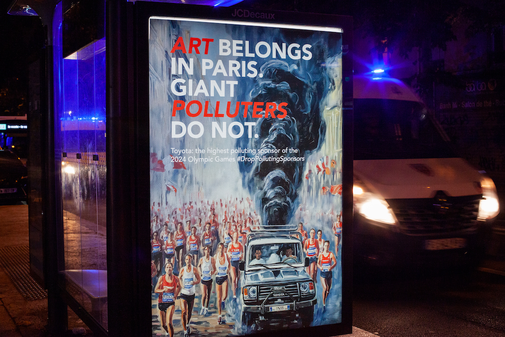 A bus stop in Paris's Place d'Italie with a poster that reads "Art belongs in Paris. Giant polluters do not."